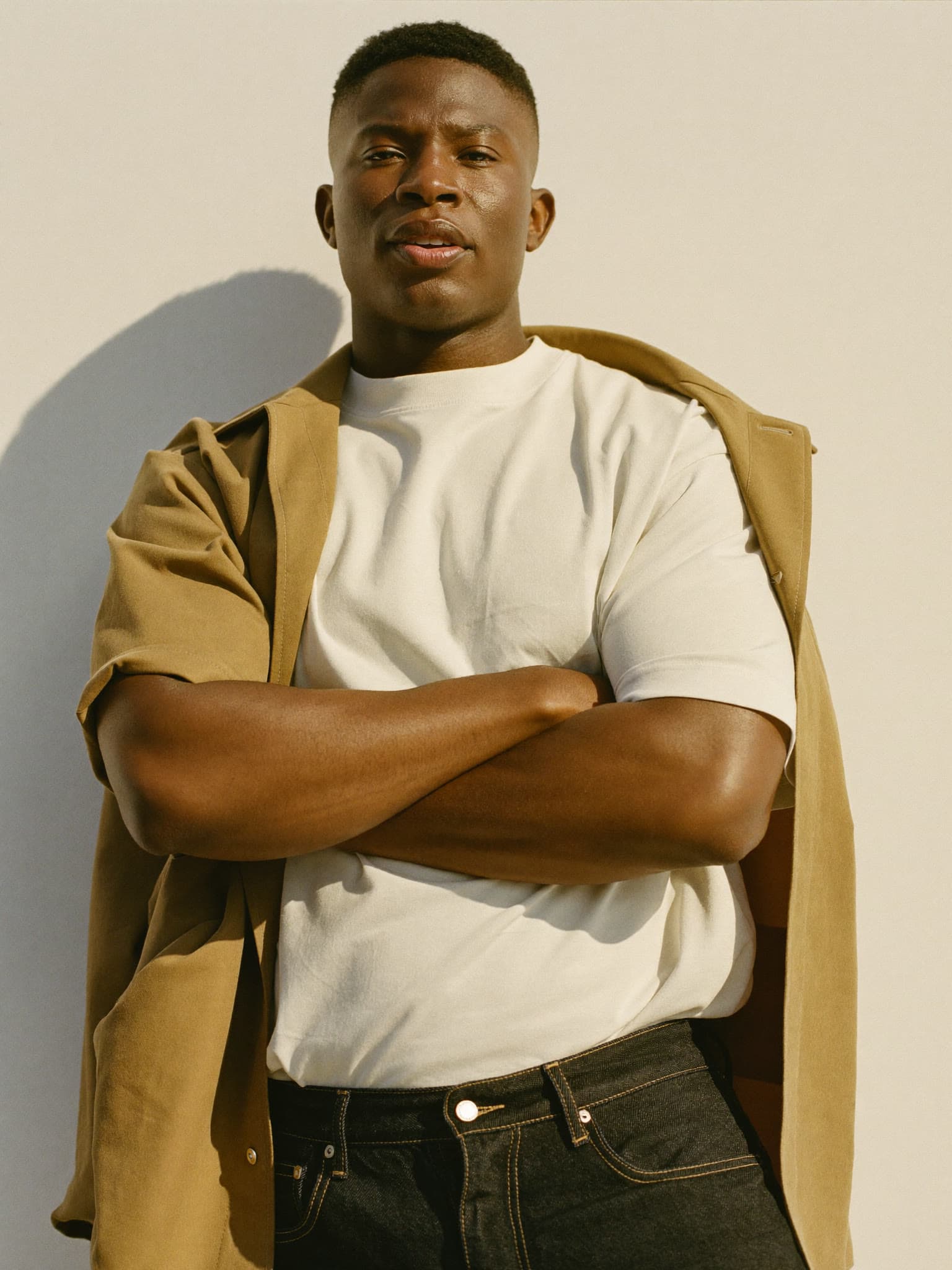 Homem de camiseta off-white com overshirt caramelo, editorial Alpha Store
